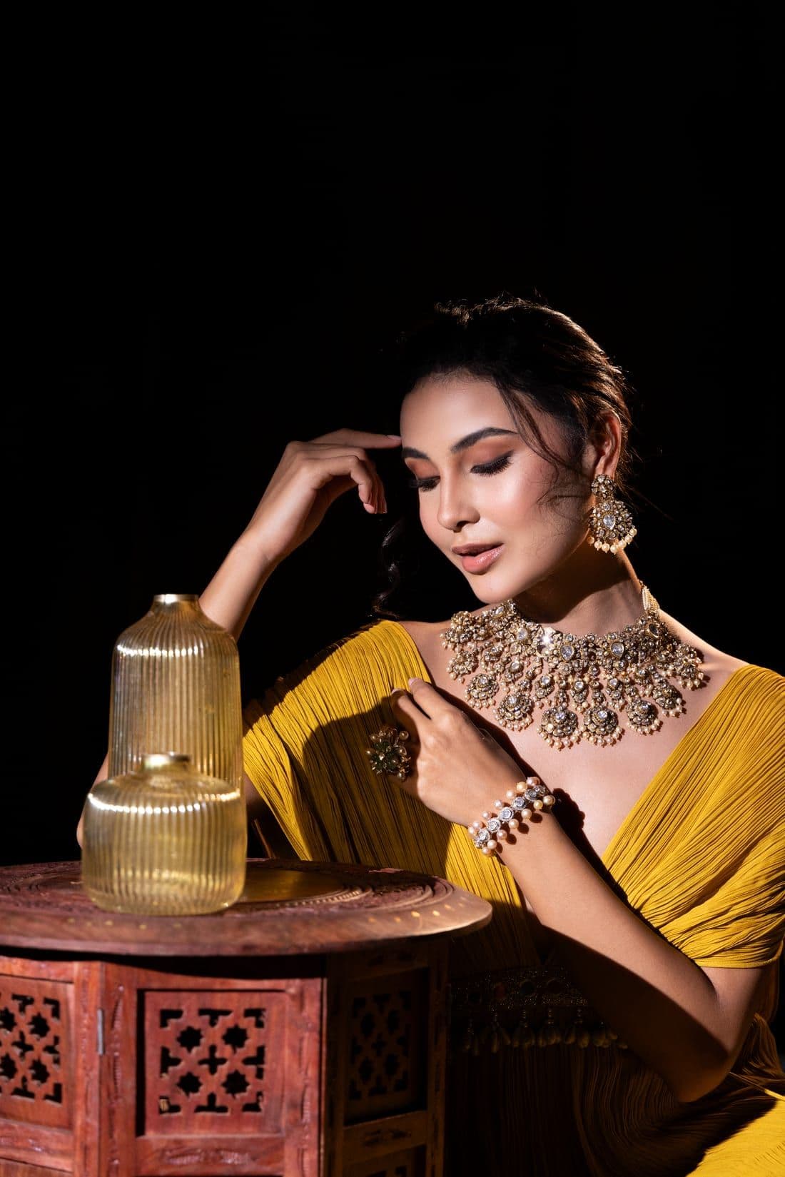 Woman in a pleated mustard drape with a polki and pearl choker