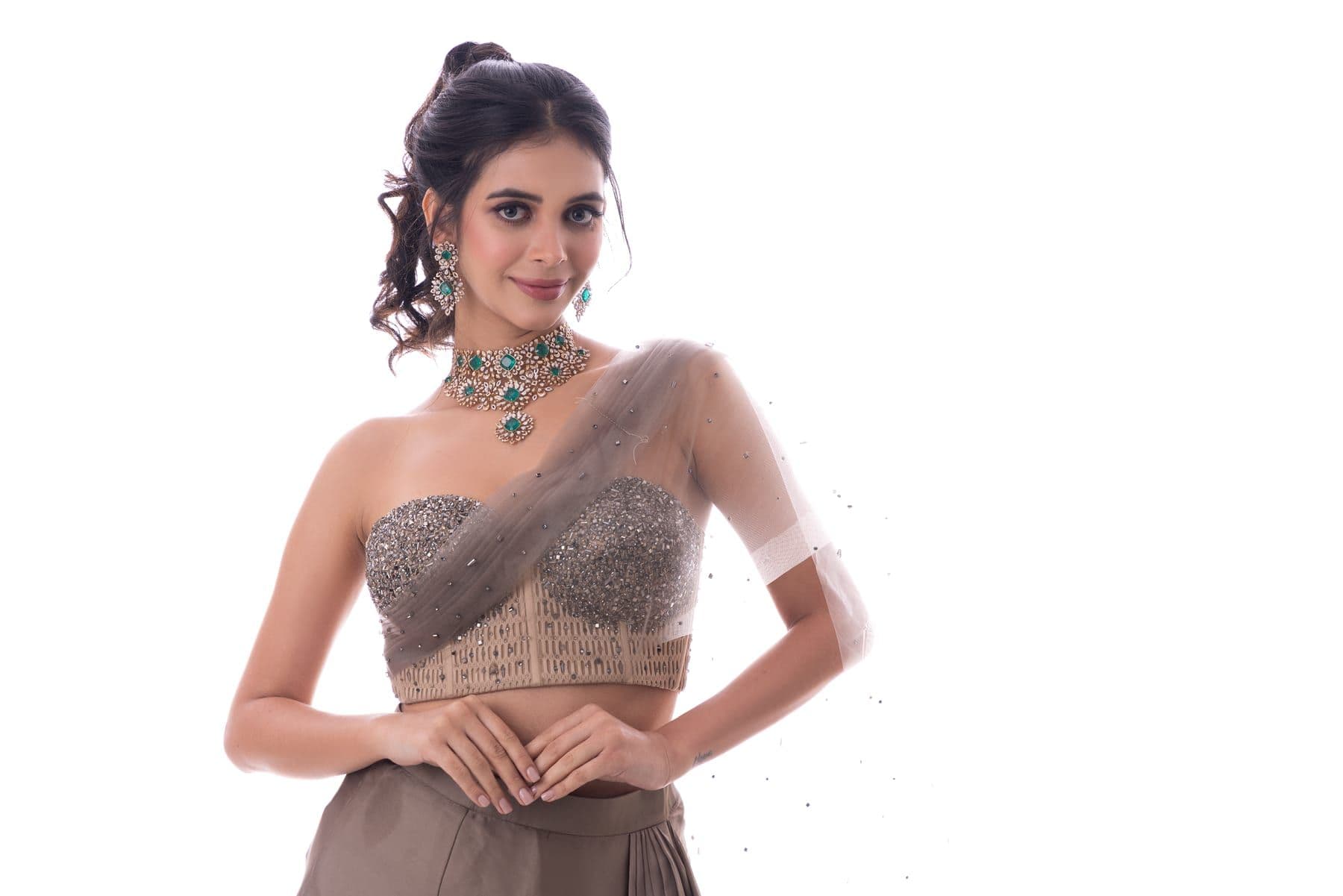 Woman in a taupe embellished corset drape with an emerald choker