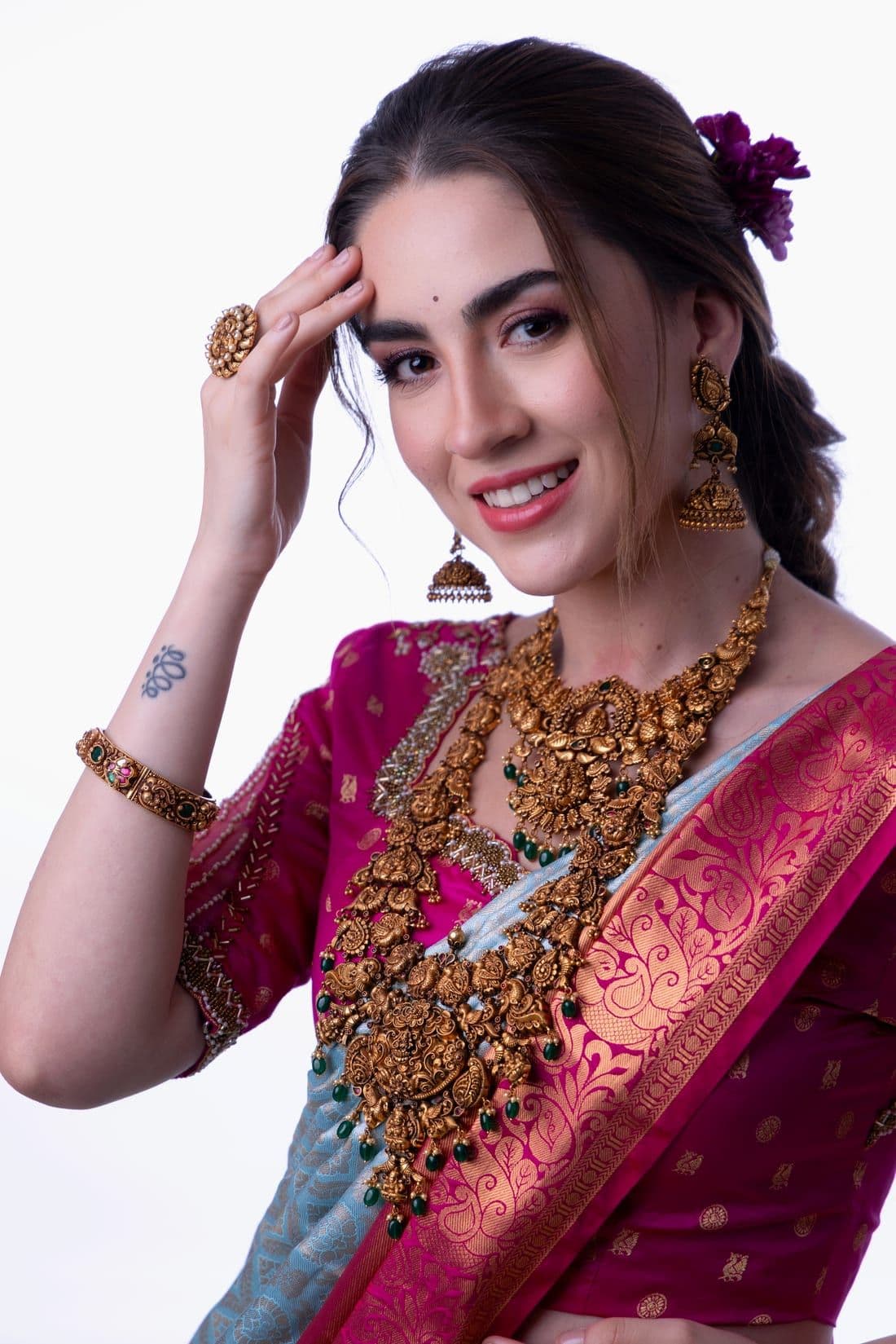 Smiling woman in a pink Kanjeevaram saree with temple jewellery