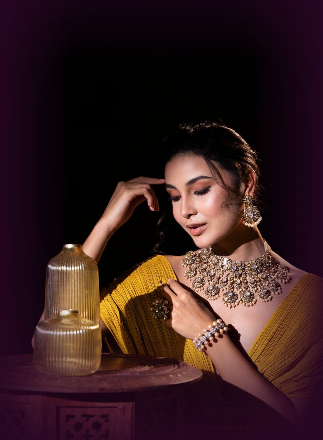 Woman in a pleated mustard drape with a polki and pearl choker